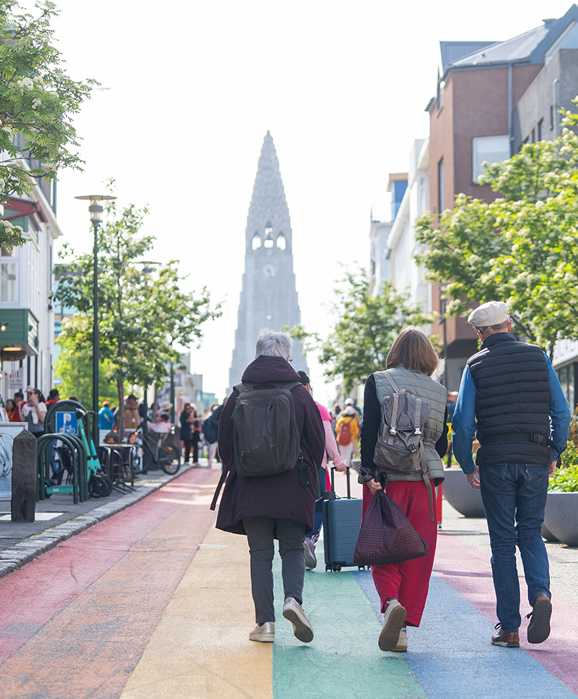 Fólk að labba upp Skólavörðustíg með Hallgrímskirkju í bakgrunni.