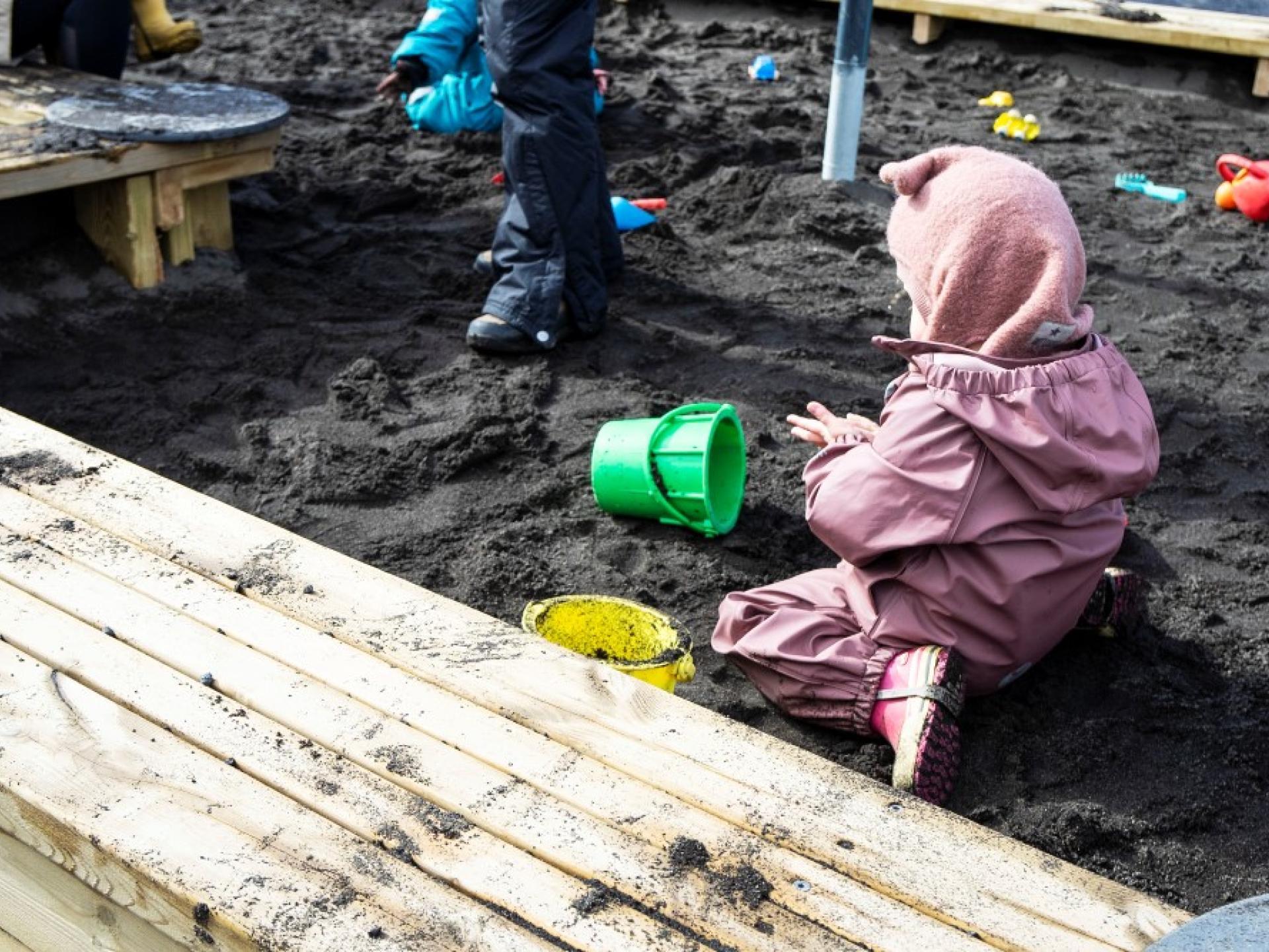 Börn að leika í sandkassa