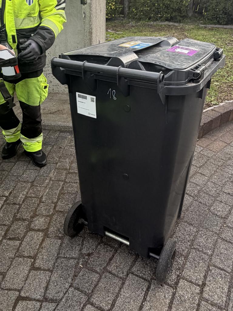 A white label affixed to a waste bin