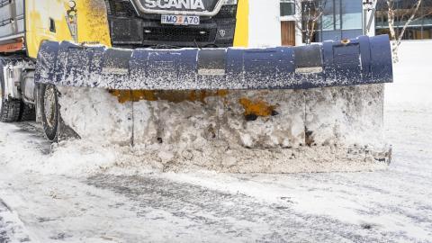 a snow plow driving on a street.